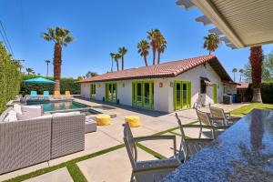 a house with a swimming pool and palm trees at Pineapple Splash! Complete Privacy! Salt Pool! in Palm Springs