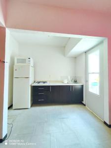 une cuisine vide avec un réfrigérateur blanc et une fenêtre dans l'établissement Hermosa casa a un paso del mar! Las mejores vacaciones para todos!!!!, à La Sabana 16 autres photos