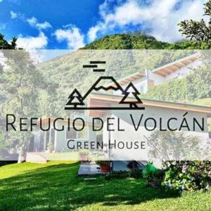 a sign for a green house with a mountain in the background at Refugio del Volcan Casitas in San Pedro La Laguna