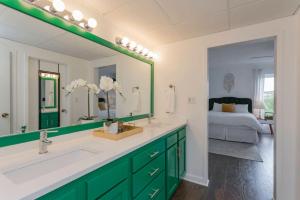 a bathroom with a sink and a mirror and a bed at Elvis Hotel But Modernized 3 Beds Pool Parking in Nashville