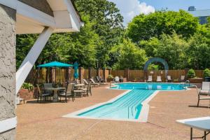 a patio with a swimming pool with chairs and a table at Home to the Stars on Music Row with Pool and Free Parking in Nashville