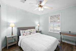 a white bedroom with a bed and a ceiling fan at Villa Island Retreat, Country house overlooking 13 acres and a small lake in Saint James City
