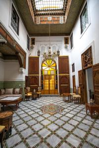 une grande chambre avec un lustre et une grande chambre avec une porte dans l'établissement Dar Usham Fes, à Fès