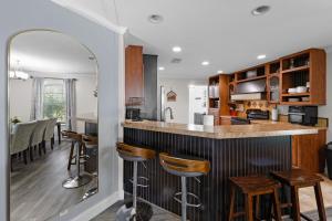 a kitchen with a bar and some stools at Villa Island Retreat, Country house overlooking 13 acres and a small lake in Saint James City