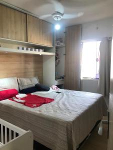 Schlafzimmer mit einem großen Bett mit roter Kleidung in der Unterkunft Casa de praia in Cabo Frio