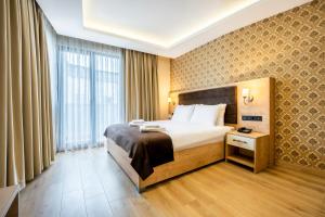 Cette chambre comprend un lit et une grande fenêtre. dans l'établissement Emin Palace, à Istanbul