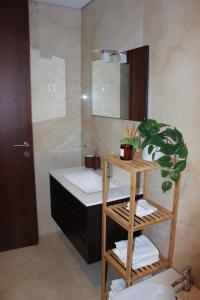a bathroom with a sink and a mirror at Apartament F&M in Braga