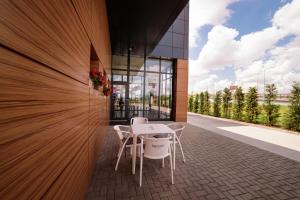 a patio with a table and chairs in front of a building at Mustang Boutique Rooms in Oradea