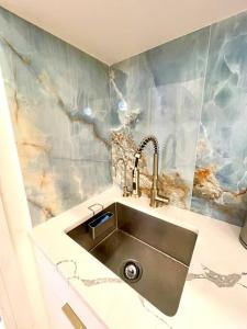 uma cozinha com um lavatório e uma parede em mármore em Ultra-Luxury stylish suite in historic Brooklyn em Brooklyn