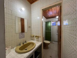 een badkamer met een wastafel, een toilet en een spiegel bij Cabañas Las Gemelas in Melgar