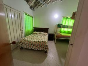 een slaapkamer met een bed en een groen raam bij Cabañas Las Gemelas in Melgar