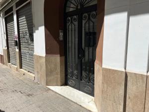 una puerta negra en el lateral de un edificio en Apto LA VICTORIA - céntrico, amplio y Parking gratuito, en Córdoba