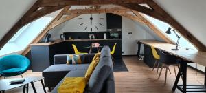 a living room with a couch and a clock on the wall at Apparthotel loft Martigné-Ferchaud in Martigné-Ferchaud