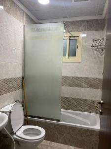 a bathroom with a toilet and a bath tub at فندق اوتاد المتحدة عبالله الخياط in Mecca