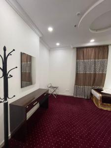 a room with a desk and a bed in it at فندق اوتاد المتحدة عبالله الخياط in Makkah