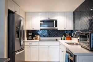 a kitchen with white cabinets and a stainless steel refrigerator at Famous Music Row Presidential Suite 2 Bedroom, 2 Bathroom, 4 Beds in Nashville