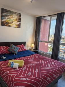 una camera con un letto con una coperta rossa e bianca di Habitación amplia en Santiago c3ntro a Santiago