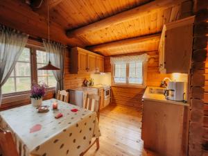 a kitchen in a log cabin with a table at Ryen Hytteutleie - Cottages in Røros
