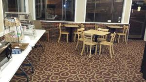 un restaurant avec des tables et des chaises sur un tapis dans l'établissement Kentucky Lake Inn, à Gilbertsville