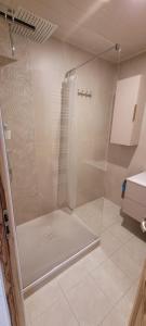 La salle de bains est pourvue d'une douche avec une porte en verre. dans l'établissement Appartement T2 de charme, à Sausset-les-Pins