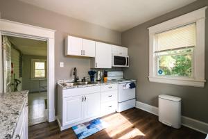 een keuken met witte kasten, een wastafel en een raam bij Cozy Roanoke Vacation Rental 2 Mi to Downtown! in Roanoke