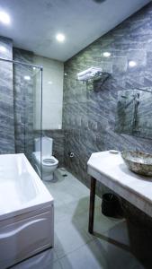 a bathroom with a sink and a toilet and a shower at Nemi Museum Hotel Baku in Baku