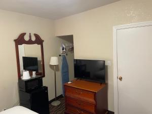 um quarto com uma televisão e uma cómoda com um espelho em Express Inn em Towson