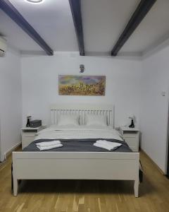 a white bedroom with a large bed in a room at Adac Boutique Hotel in Bucharest