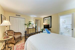 um quarto com uma cama e uma cadeira e uma casa de banho em Sea Grape Inn 4- BEACHFRONT Property em Longboat Key