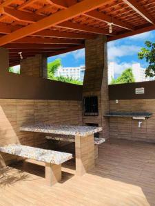 a patio with tables and benches in a building at Ecologic Park, apt 2 quartos 900 mt do centro de Caldas Novas in Caldas Novas
