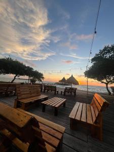 un grupo de mesas de picnic en la playa con la puesta de sol en Tintipan Hotel, en Tintipan Island