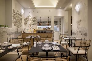 um restaurante com mesas e cadeiras e uma cozinha em Hôtel L de Lutèce em Paris