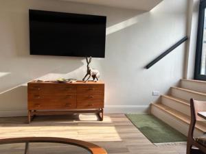 a living room with a flat screen tv on a wall at The Curious Apartment, Cheltenham in Cheltenham