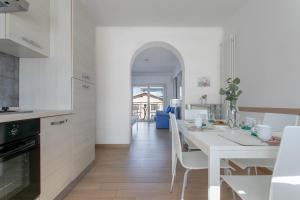 - une cuisine blanche avec une table et des chaises blanches dans l'établissement Grazioso appartamento seconda fila sul mare - wifi, à Roseto degli Abruzzi