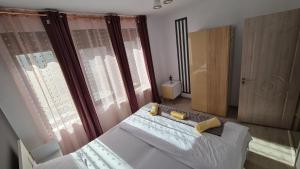 ein Schlafzimmer mit einem Bett und einem großen Fenster in der Unterkunft Pomiculturii Residence 1 in Timişoara