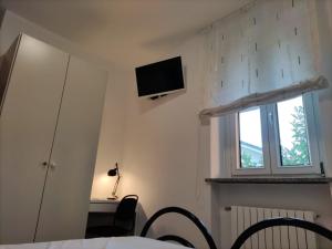 a bedroom with a bed and a tv on the wall at B&B Ariosto 26 in Rho