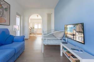 un salon avec un canapé bleu et une télévision dans l'établissement Grazioso appartamento seconda fila sul mare - wifi, à Roseto degli Abruzzi