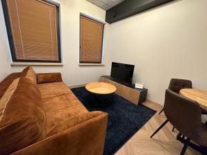 uma sala de estar com um sofá, uma mesa e uma televisão em MyCasa Paupys em Vilnius