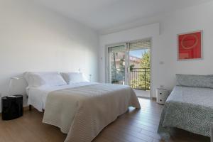 - une chambre blanche avec un lit et une fenêtre dans l'établissement Grazioso appartamento seconda fila sul mare - wifi, à Roseto degli Abruzzi