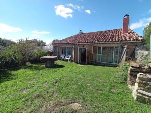 a house with two white chairs in a yard at La Majada del Puente in El Royo