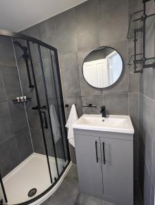 a bathroom with a shower and a sink and a mirror at House in Barnes in London