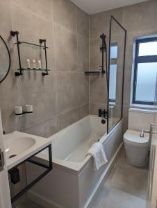 a bathroom with a tub and a toilet and a sink at House in Barnes in London