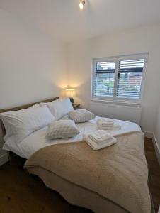 a bedroom with a bed with two towels on it at House in Barnes in London