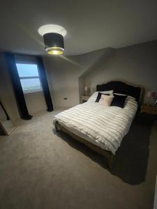 een slaapkamer met een groot bed en een raam bij Coastal home with lots of space 5 bedrooms. in Buckhaven