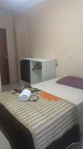 una cama con un sombrero blanco sentado encima en Hotel Pousada Aeroporto, en Goiânia