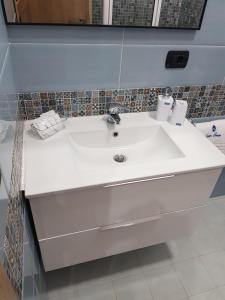 um lavatório branco na casa de banho com um espelho em B&B Gisa House em Pomigliano dʼArco