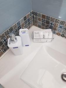 uma casa de banho branca com um secador de cabelo e uma máquina de barbear em B&B Gisa House em Pomigliano dʼArco