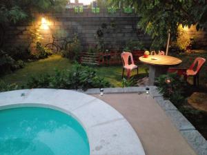 a swimming pool in a yard with a table and chairs at Dpto La Bicicleta solar in Villa Independencia
