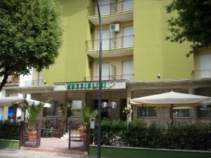 カストロカーロ・テルメにあるHotel Muccioliniの傘を前に置いた緑の建物