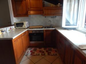 cocina con armarios de madera, fregadero y microondas en Gala, en Casarza Ligure